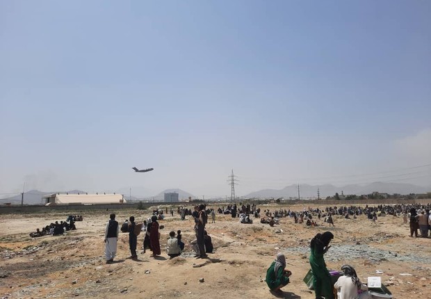 Afegãos esperam para tentar ter acesso à aeroporto (Foto: Sayed Khodaiberdi Sadat/Anadolu Agency via Getty Images)