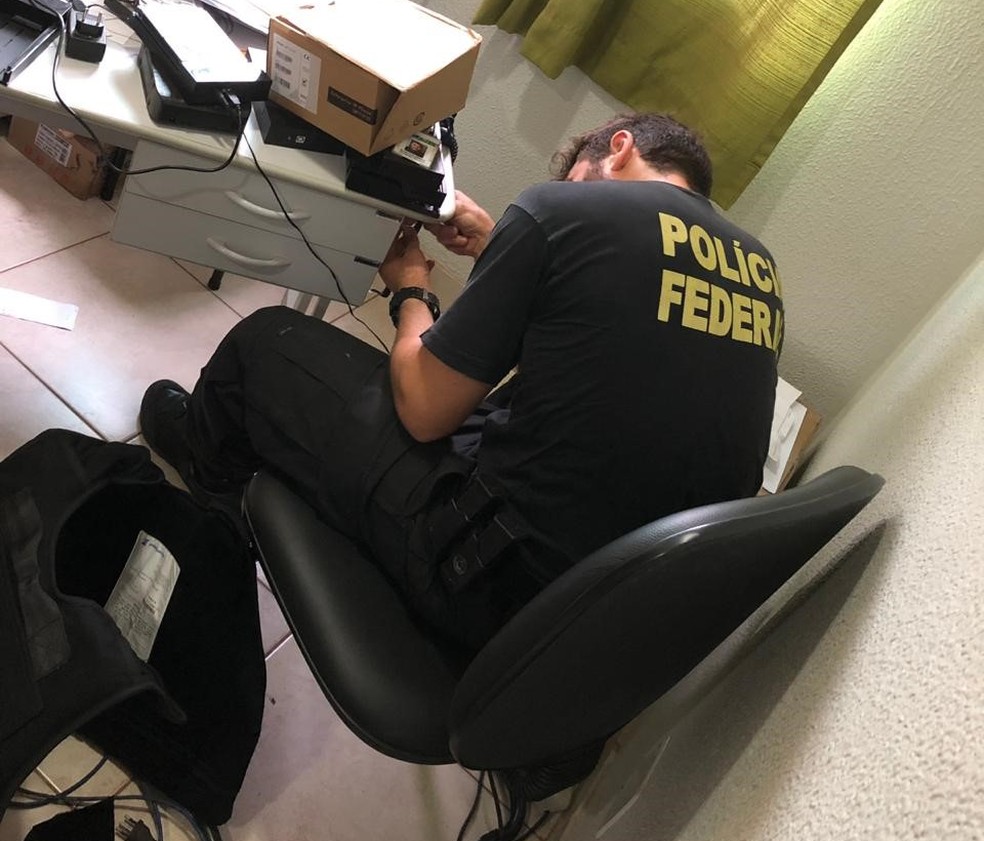 Policial federal analisa material recolhido durante operação Bandeirantes, em Brasília — Foto: Polícia Federal/ Divulgação