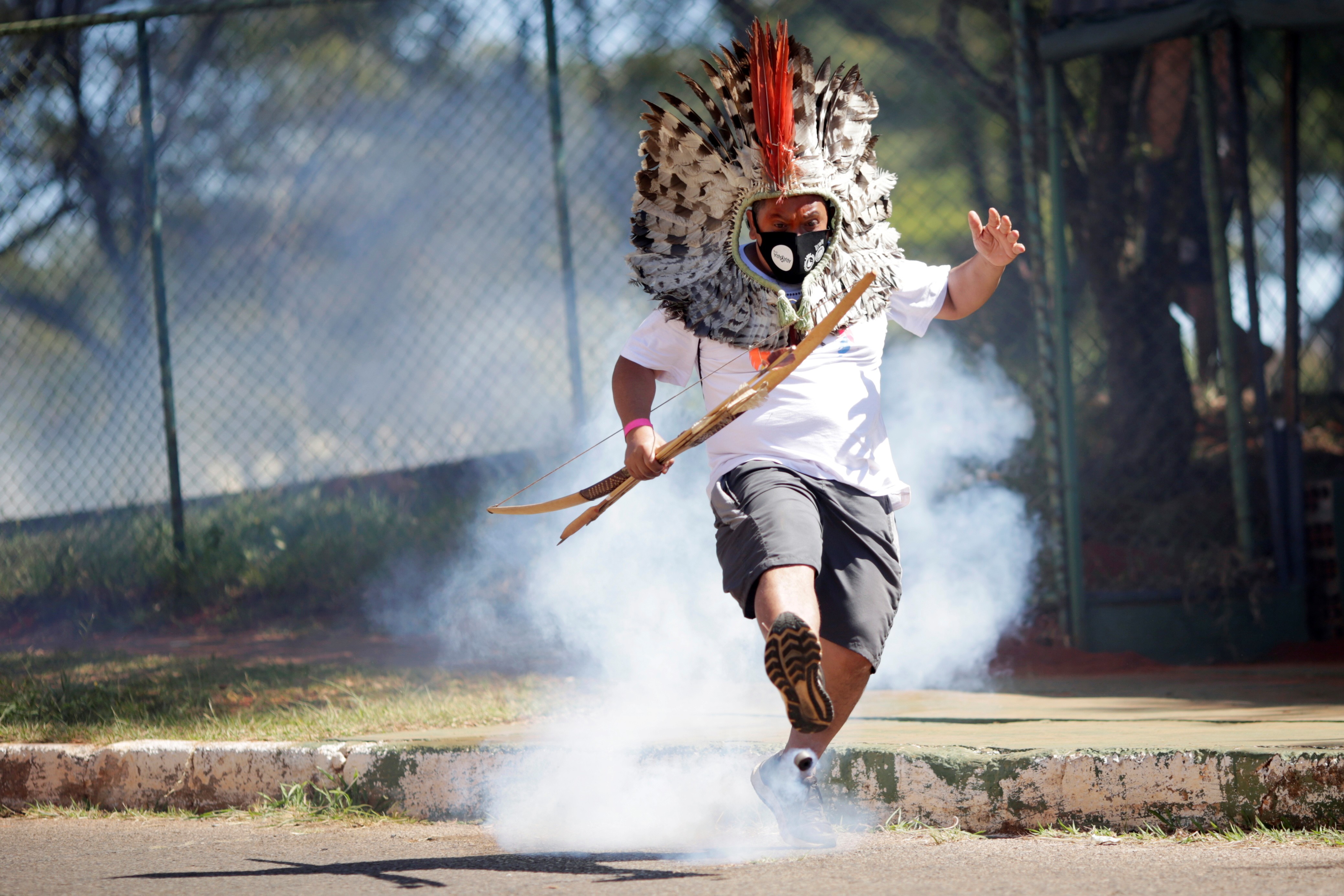 Líder indígena Kretan Kaingang chuta de volta bomba de gás lacrimogêneo lançada pela polícia contra indígenas durante protesto em frente ao Congresso 22/06/2021 (Foto: REUTERS/Ueslei Marcelino)