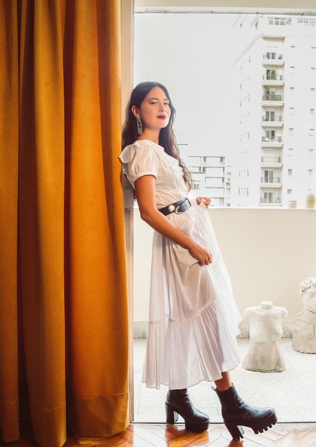 Fotografada em seu apartamento em São Paulo, Luciana Hosoi usa vestido Saint Laurent, brincos Paola Vilas, cinto comprado em um brechó em Londres e botas Stella McCartney.  (Foto: Jef Delgado)