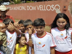 Idoso posa ao lado dos netos que estudam na Escola Dom Velloso, em Itumbiara, Goiás (Foto: Adriano Zago/G1)