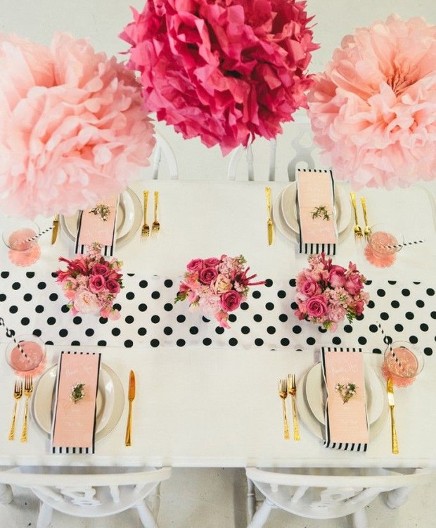 Mix de estampas sem erro: os guardanapos listrados e o caminho de mesa em poá em preto e branco dão supercerto juntos. As flores de papel em tons de rosa dão o toque final de elegância à mesa.  (Foto: Reprodução/Pinterest)