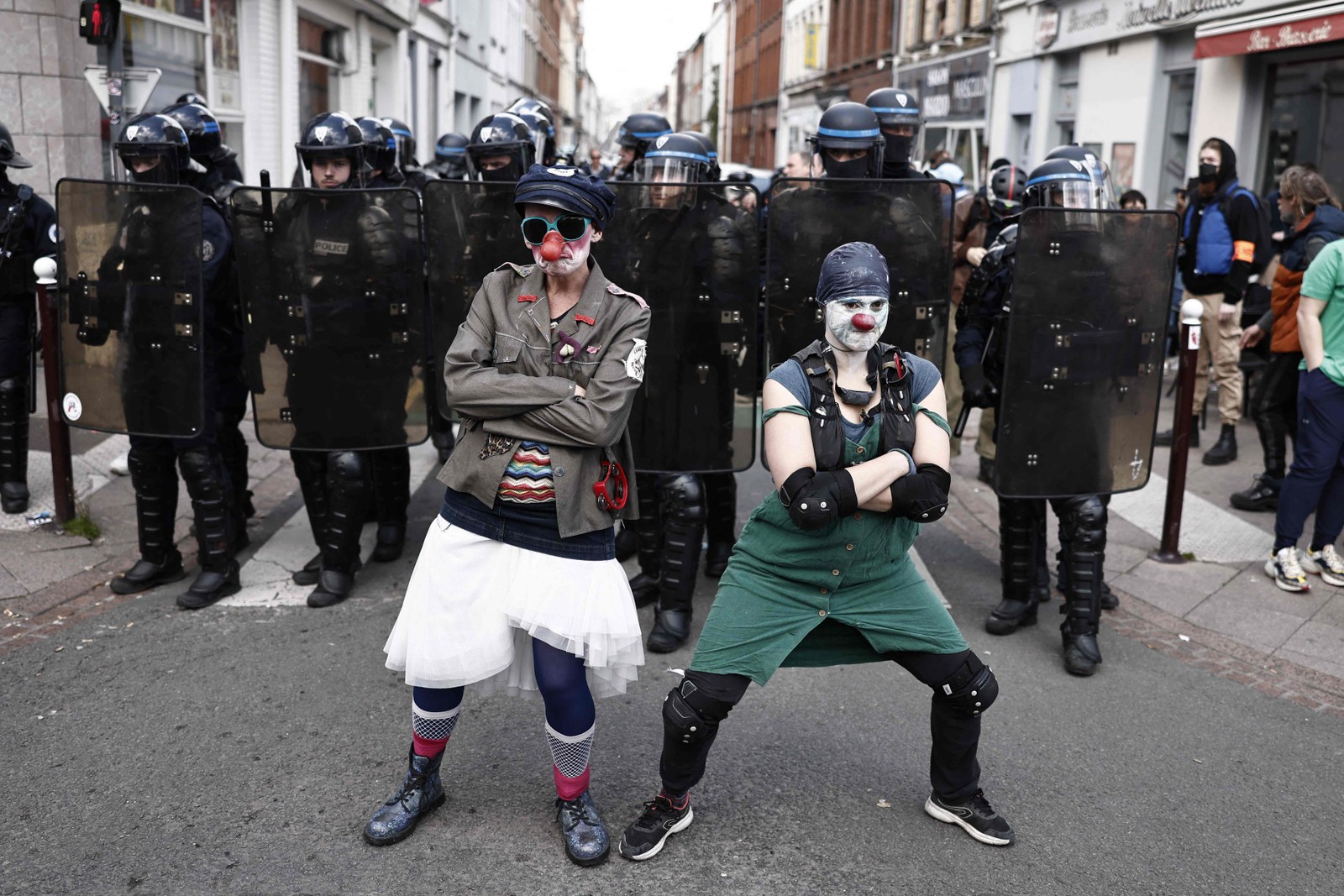 Manifestantes vestidos de palhaços posam em frente à polícia francesa durante protesto em Lille, no norte da França — Foto: Sameer Al-Doumy / AFP