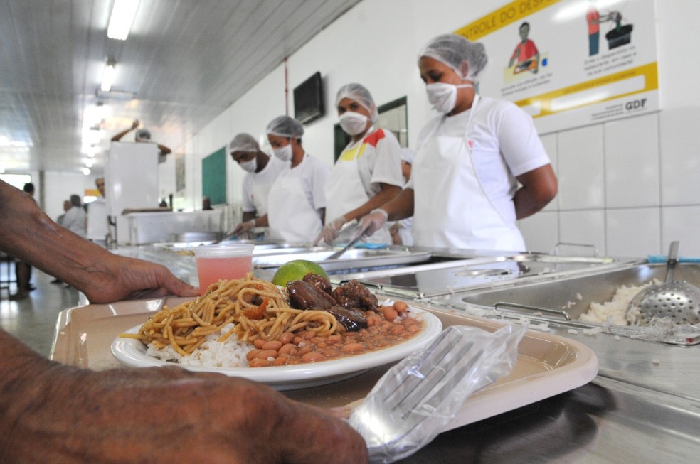 Funcionários de restaurante comunitário do DF servem refeição — Foto: Paulo H. Carvalho/Agência Brasília