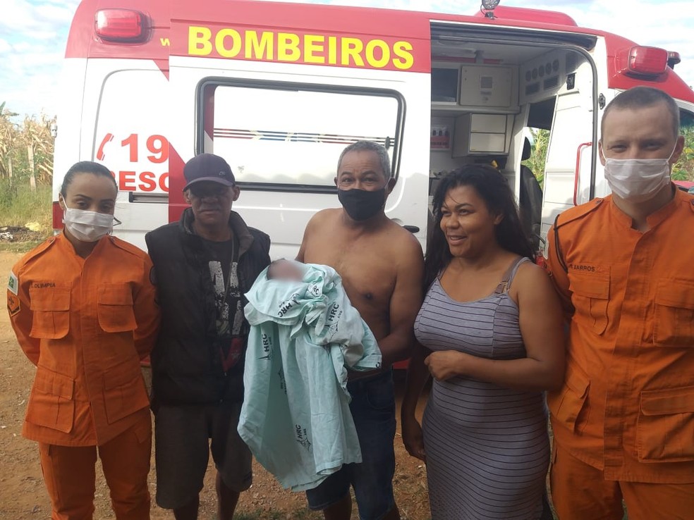 Ao lado da esposa, sargento do Corpo de Bombeiros segura menina encontrada dentro de depósito de lixo, no DF; na foto, catador que escutou choro da criança e outros militares da corporação — Foto: Arquivo pessoal