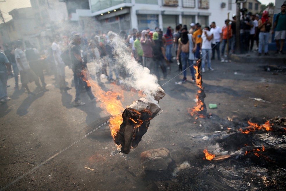 Manifestantes queimam roupas durante protesto contra forÃ§as de seguranÃ§a em UreÃ±a, na fronteira entre a ColÃ´mbia e a Venezuela, neste sÃ¡bado (23). â€” Foto: REUTERS/Andres Martinez Casares