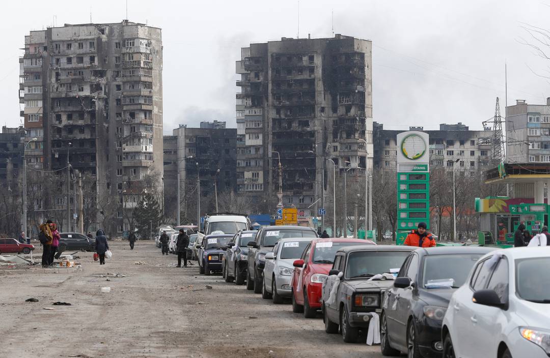 Carros com vidros estilhaçados, marcas de tiro e bandeiras brancas deixam Mariupol nesta quinta-feira (17).