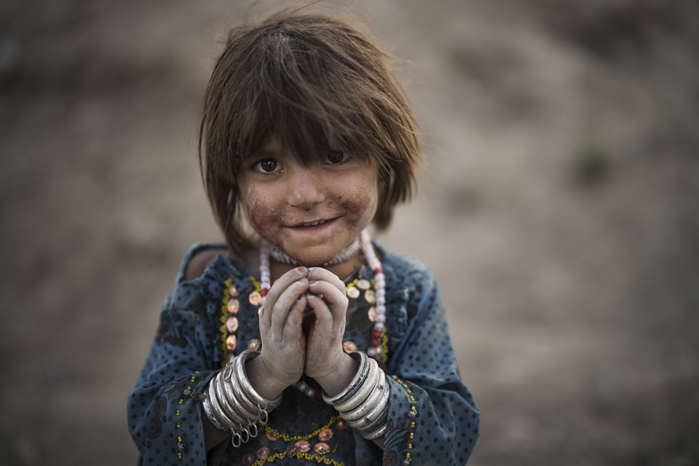27 de setembro - Laila posa para uma foto, enquanto brinca em um campo de refugiados nas redondezas de Cabul, no Afeganistão — Foto: Felipe Dana/AP