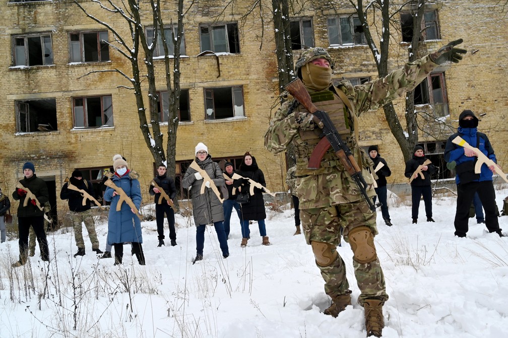 30 de janeiro - Instrutor militar treina civis, segurando rplicas de fuzis em madeira, em uma fbrica abandonada na capital ucraniana de Kiev — Foto: Sergei Supinsky/AFP