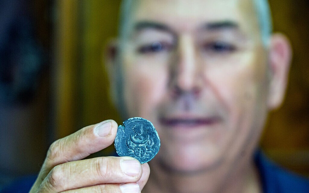 Jacob Sharvit, diretor da Unidade de Arqueologia Marítima da Autoridade de Antiguidades de Israel, segurando a moeda  (Foto: Yaniv Berman/Israel Antiquities Authority)