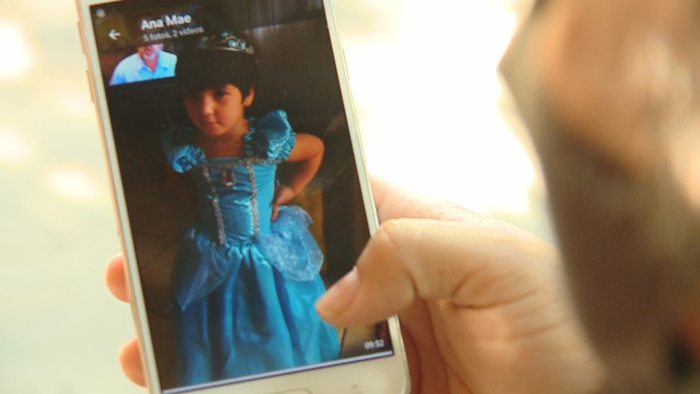 Mãe observa fotos de Ana Clara no celular — Foto: Reprodução/RBS TV