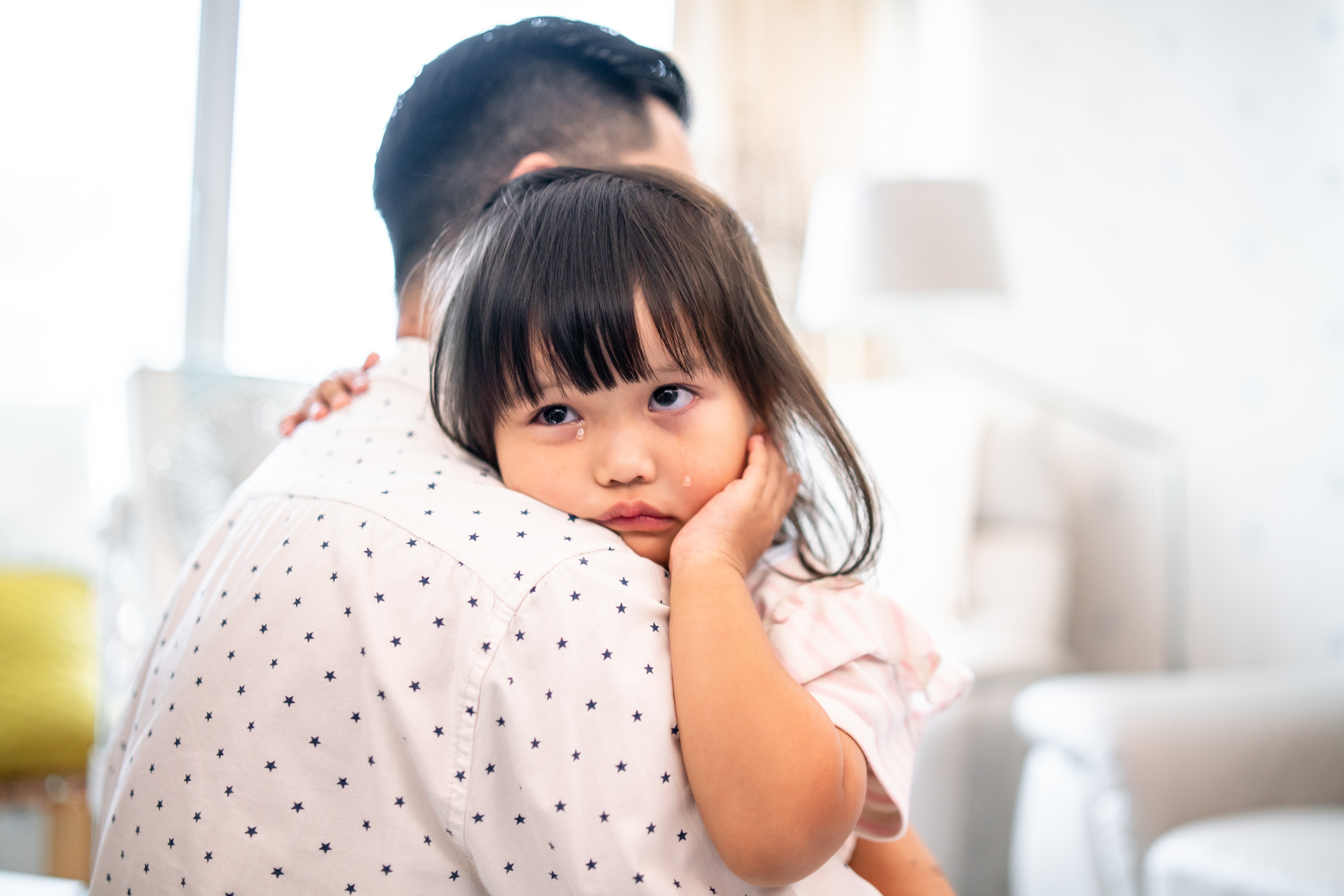 Criança chorando no colo do pai (Foto: Getty Images)