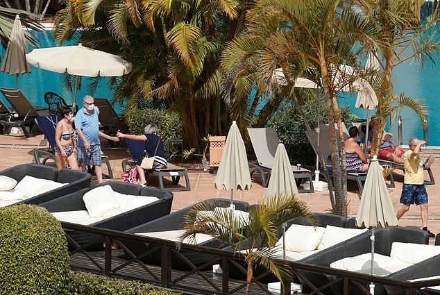 Hóspedes com máscaras à beira da piscina em hotel nas Ilhas Canárias (Foto: Reprodução)