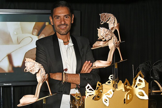 Angelo Ruggeri, the design director of Sergio Rossi, with the butterfly-inspired shoes and pochettes shoes he created (Foto: Getty )
