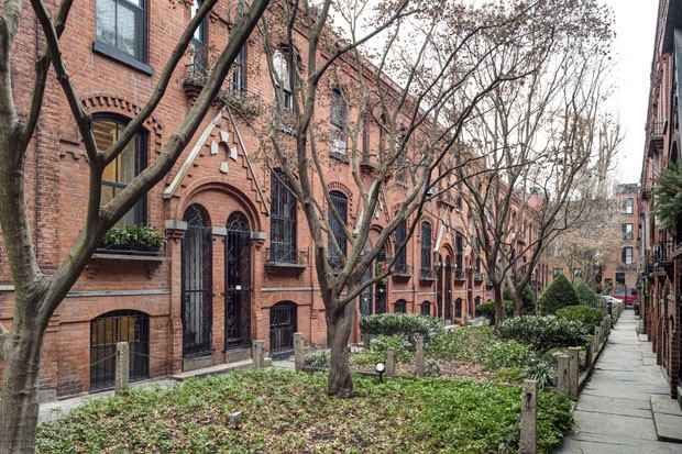 A row of vintage townhouses in the Cobble Hill neighborhood of Brooklyn, built for workers in the 1870s, in New York, Dec. 16, 2014. The garden-like courtyard is closed off by iron grates, and units have private parking spaces, but the units as built had  (Foto: NYT)