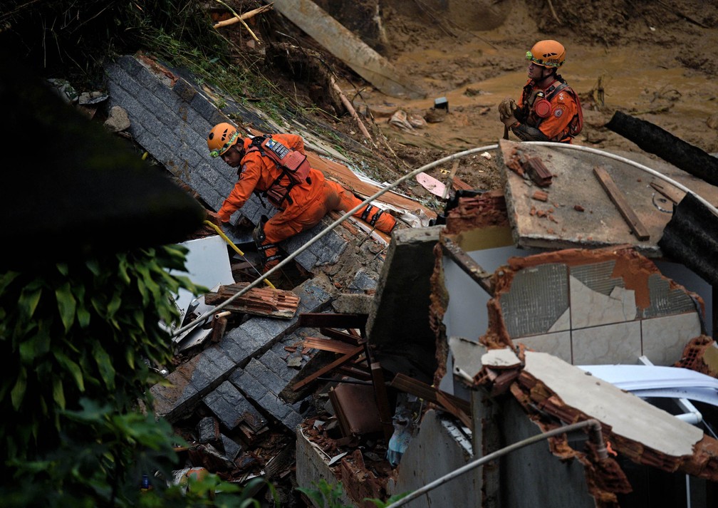Bombeiros trabalham na busca por vítimas após deslizamento no Morro da Oficina, em Petrópolis (RJ), nesta quarta (16) — Foto: Carl de Souza/AFP