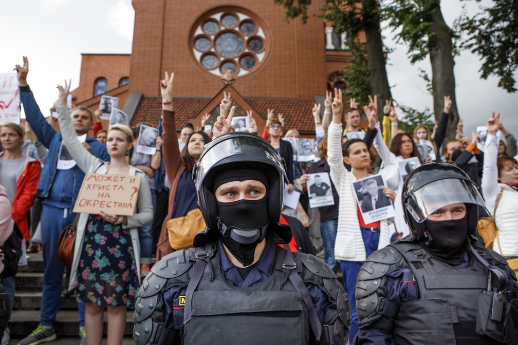 Polícia bloqueia manifestantes conta Lukashenko que protestavam em frente a igreja em Minsk, capital de Belarus, nesta quinta-feira (27) — Foto: Dasha Sapranetskaya/AP Photo