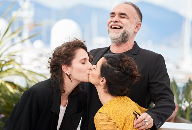 As atrizes Carol Duarte e Julia Stockler divertem o diretor Karim Ainouz ao dar selinho em tapete vermelho de Cannes (Foto: Getty Images)