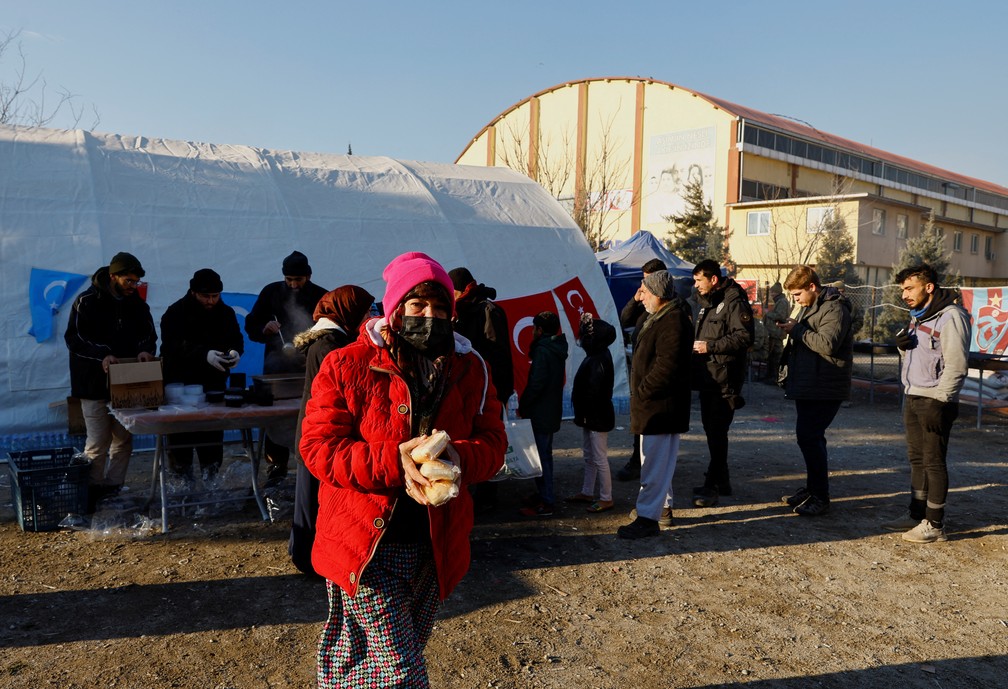 População de Kahramanmaras recebe alimentos em acampamento montado diante de estádio na Turquia — Foto: Suhaib Salem/REUTERS