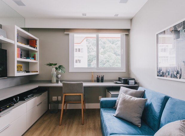 Uma característica em comum entre os sofás de toda a casa é a cor. Tanto na sala, quanto no escritório, eles são usados para fugir da paleta sóbria (Foto: Giraldi Ineves/ Divulgação)