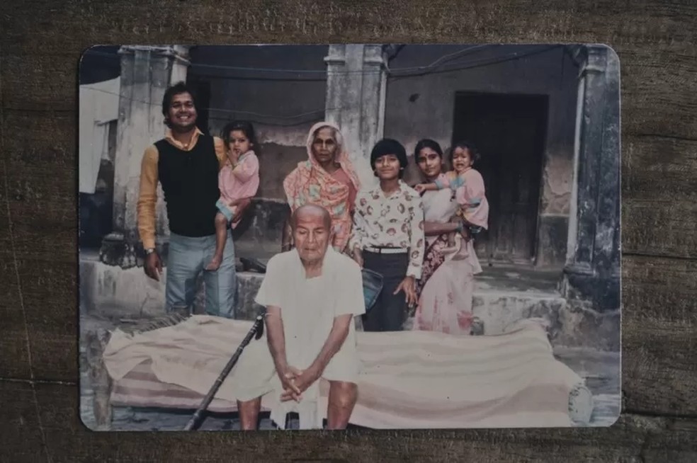 Gosain (à esquerda, com a filha no colo), Kameshwar Singh (sentado) e Ramsakhi Devi (atrás de Singh) — Foto: Ronny Sen via BBC