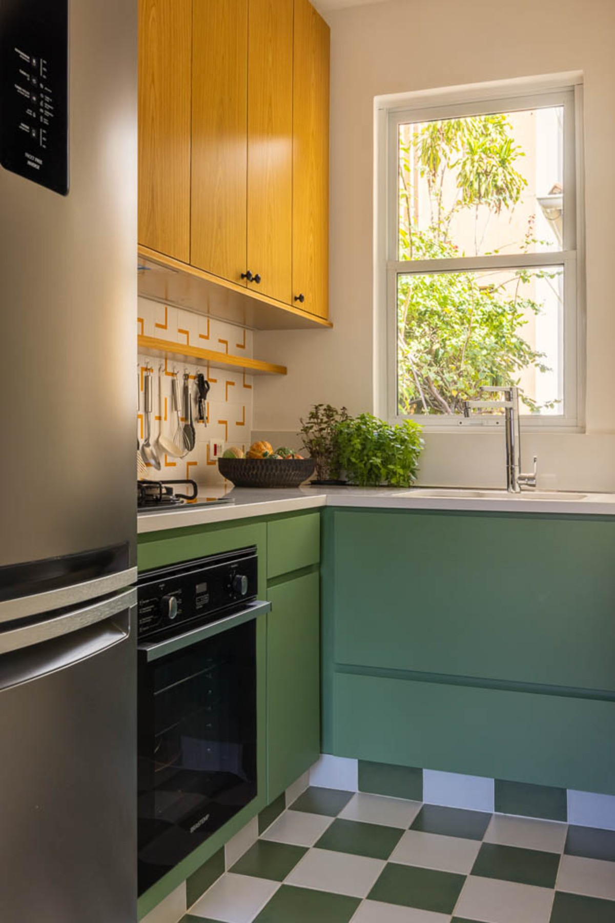 COZINHA | Os tons de verde tornam a cozinha ainda mais elegante. Pela janela é possível ver as plantas do lado de fora e integram a natureza com o espaço (Foto: André Nazareth / Divulgação)