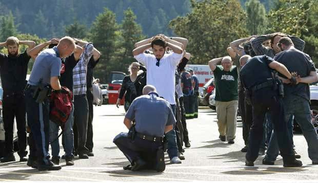 Estudantes são revistados ao sair da faculdade Umpqua, no Oregon, após atirador invadir e disparar (Foto: Mike Sullivan/Roseburg News-Review via AP)