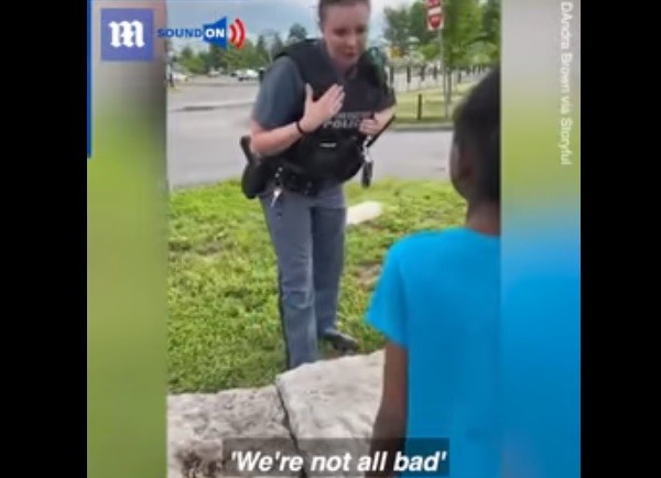 Policial tenta acalmar menina negra que se desesperou ao ver a polícia (Foto: Reprodução/Daily Mail)
