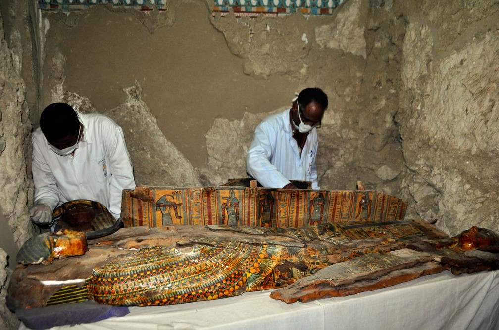  Membros da equipe de arqueólogos do Egito trabalham em sarcófago de madeira descoberto em uma tumba de 3,5 mil anos na necrópolis de Abu el-Naga, perto da cidade de Luxor, no Egito  (Foto: Stringer/AFP)