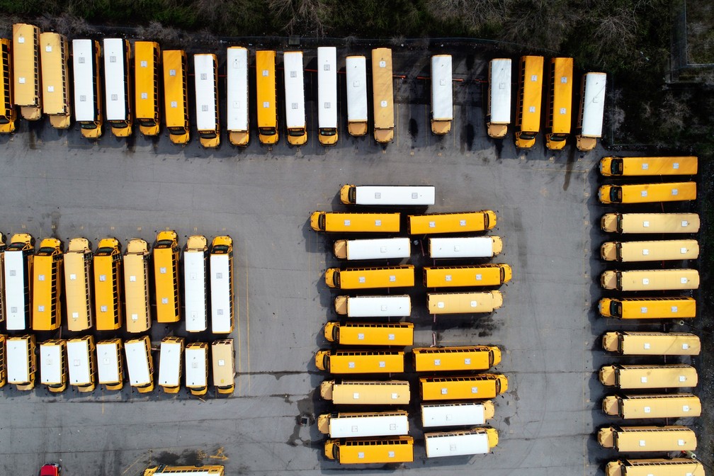 Ônibus escolares ficam sem uso em um estacionamento na quinta-feira, 26 de março, em St. Louis, nos EUA. Todas as escolas públicas no Missouri estão fechadas devido à pandemia do coronavírus — Foto:  Jeff Roberson/AP