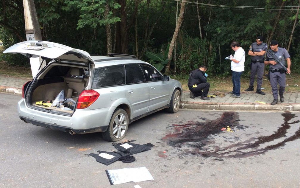 PolÃ­cia e poÃ§a de sangue em local onde criminosos foram mortos apÃ³s tentativa de assalto a bancos de Guararema, em SÃ£o Paulo â?? Foto: Giba Bergamin/TV Globo