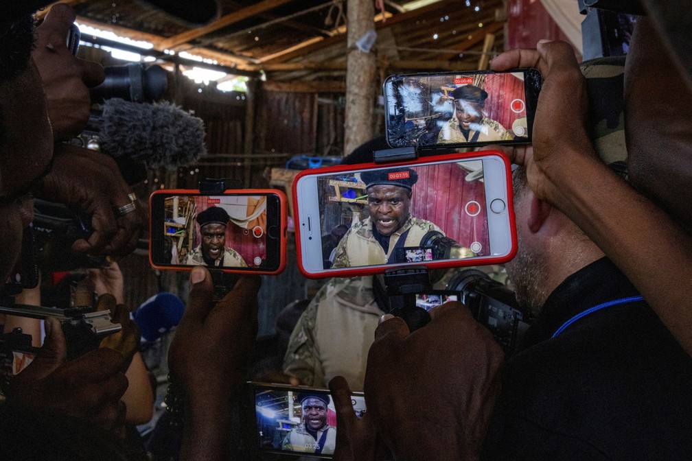 3 de novembro - Jornalistas filmam o ex-policial Jimmy "Barbecue" Cherizier, líder da coalizão 'G9', em um tour para a imprensa na favela La Saline em Porto Príncipe, no Haiti   — Foto: Adrees Latif/Reuters