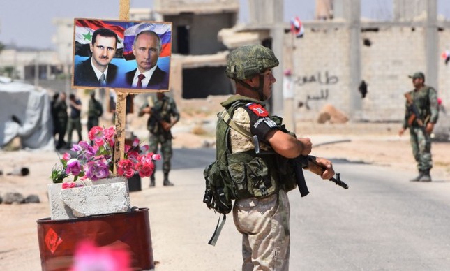 Soldados perto de imagens dos presidente da Síria, Bashar al-Assad, e da Rússia, Vladimir Putin