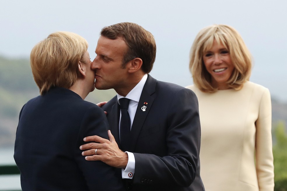 Emmanuel Macron cumprimenta a chanceler alemã Angela Merkel com um beijo no rosto durante a cúpula do G7 celebrada em Biarritz em agosto de 2019 — Foto: Francois Mori/pool via AFP/Arquivo