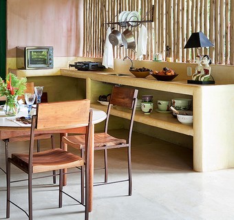 Simples de tudo, a cozinha da casa de praia de Roberto Maya tem bancada e prateleiras de alvenaria – e só. O ripado de bambu sustenta o paneleiro