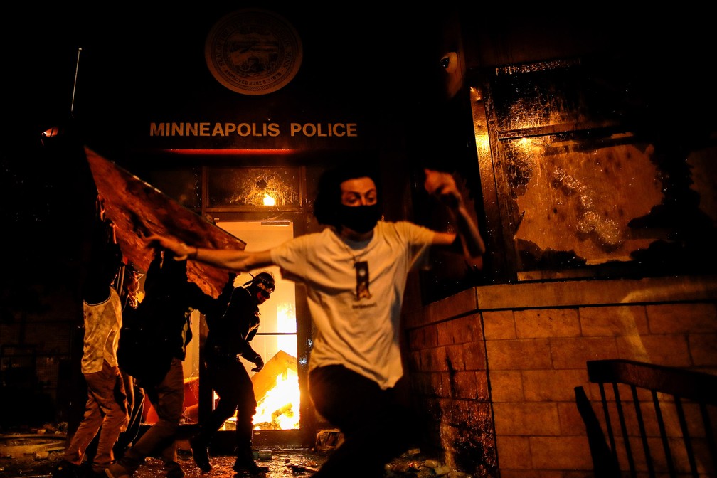 28 de maio - Manifestantes ateiam fogo na entrada de uma delegacia de polícia durante as manifestações pela morte de George Floyd em Minneapolis, nos EUA — Foto: Carlos Barria/Reuters