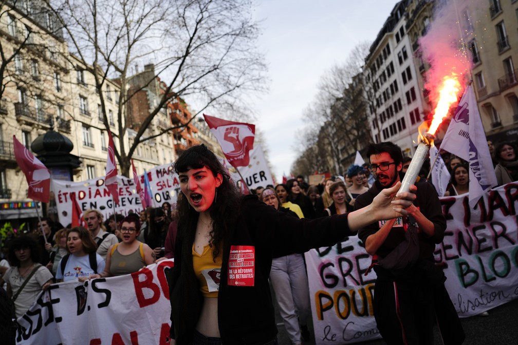 Protestante segura sinalizador na mão durante manifestação em Paris em 16 de março de 2023 — Foto: Lewis Joly/AP