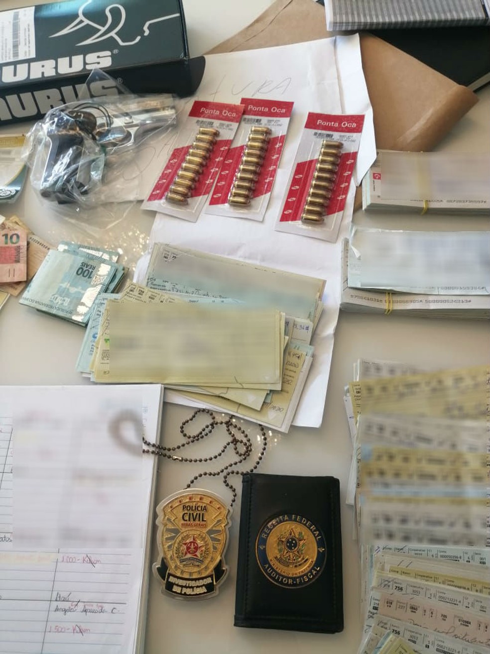 Dinheiro, cheques e munição apreendida durante operação em Patos de Minas — Foto: MPMG/Divulgação