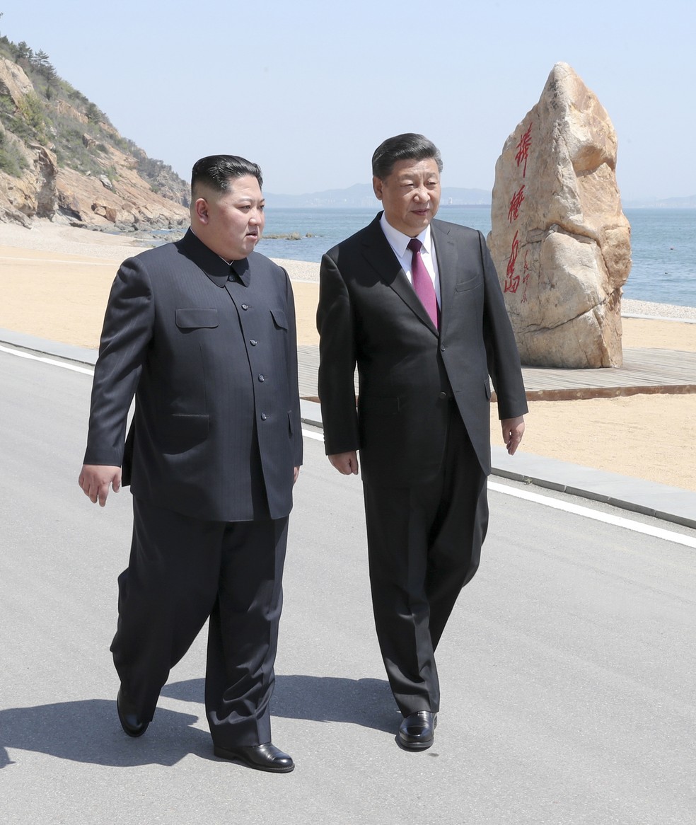 O lÃ­der norte-coreano Kim Jong-un e o presidente chinÃªs Xi Jinping caminham por Dalian, na China; foto tirada entre segunda (7) e terÃ§a-feira (8) foi divulgada pela agÃªncia oficial chinesa Xinhua (Foto: Ju Peng/Xinhua via AP)