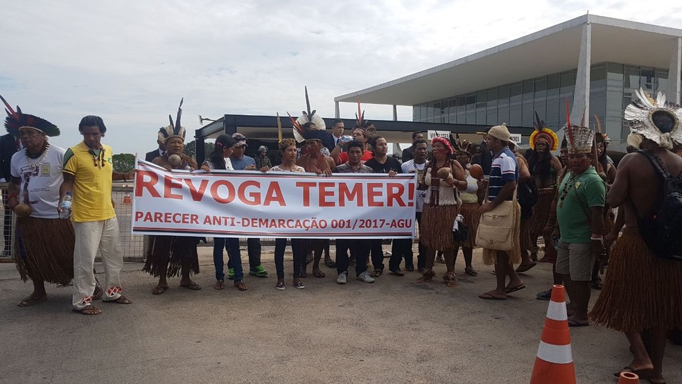 Indígenas exibem faixa no Palácio do Planalto pedindo a revocação de parecer da AGU sobre demarcação de terras (Foto: Marina Oliveira/G1)