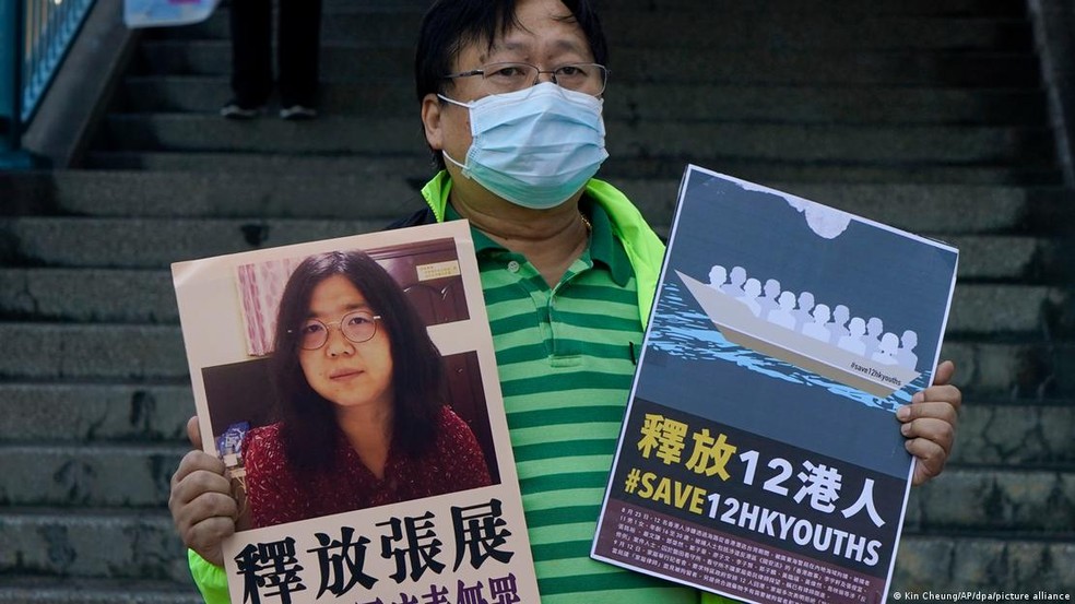 Ativista pró-democracia porta cartaz com foto de Zhang Zhan, em protesto contra regime chinês — Foto: Kin Cheung/AP