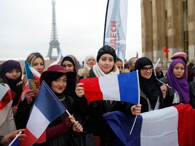   Mulheres seguram bandeiras da França em manifestação neste domingo (13), um mês após ataques  (Foto: Reuters/Stephane Mahe)