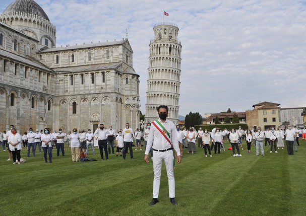 PISA, ITALY - MAY 30:  Mayor of Pisa Michele Conti and people wearing face masks while keeping social distances take part in a flash mob near the tower of Pisa on May 30, 2020 in Pisa, Italy. The city of Pisa in Piazza dei Miracoli celebrated the reopenin (Foto: Getty Images)
