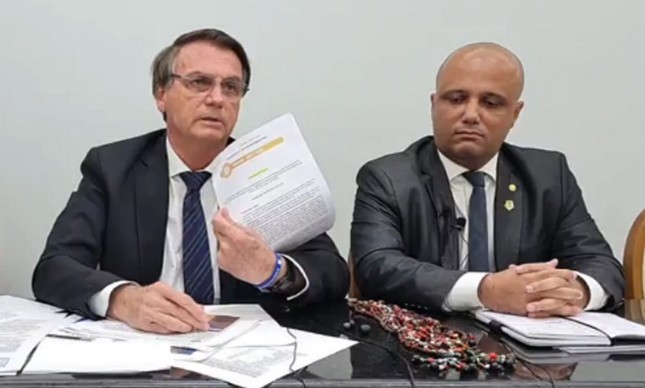 O presidente Jair Bolsonaro, durante transmissão nas suas redes sociais. Ao seu lado, o deputado federal Victor Hugo