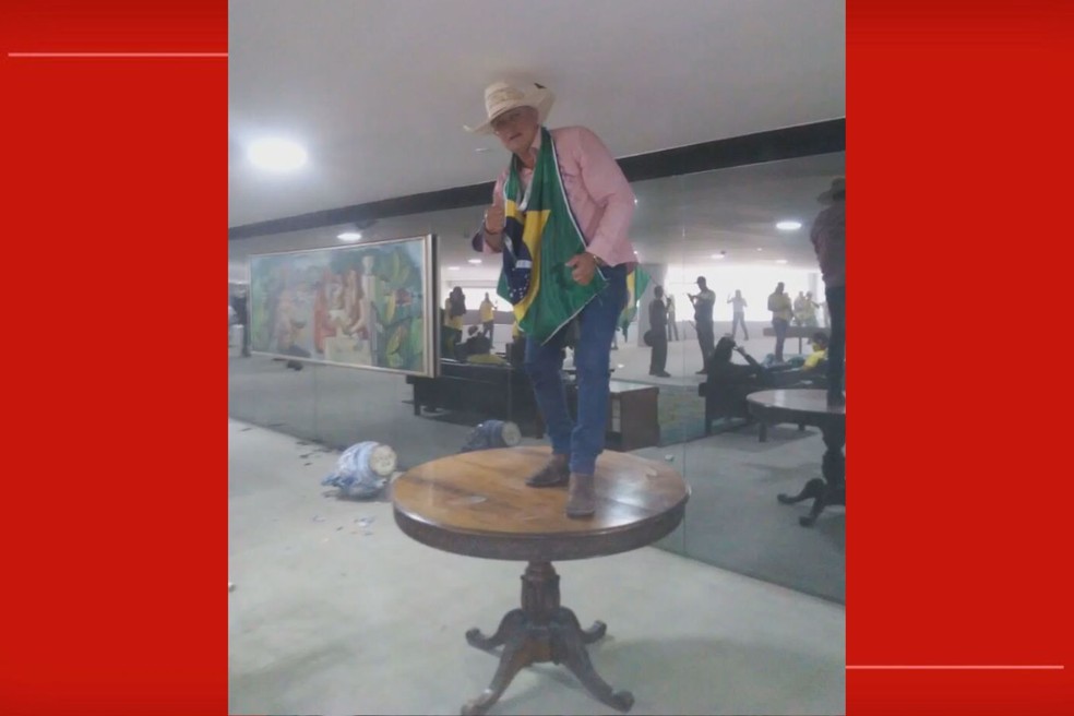 Bolsonarista em cima de mesa no Palácio do Planalto, durante ataques em Brasília — Foto: Reprodução