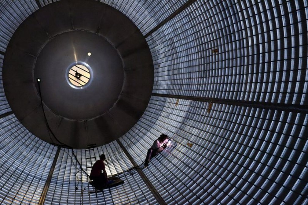 Trabalhadores dentro do tanque de hidrogênio dos SLS fazem manutenção nas paredes — Foto: Nasa via BBC