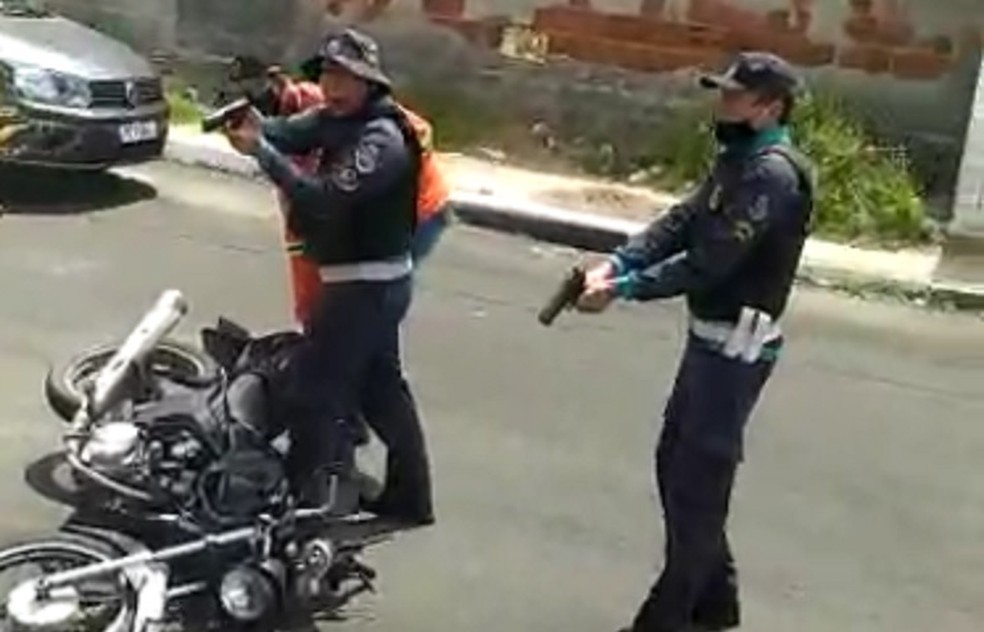 Policial aponta arma para homem que quebrava a própria moto em Fortaleza. — Foto: Reprodução