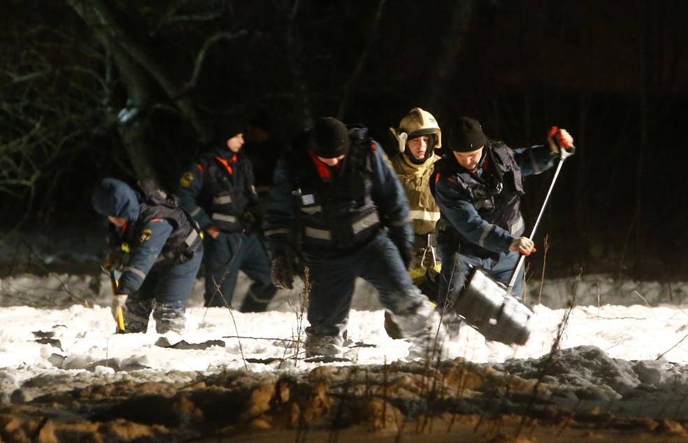 Equipes de emergência trabalham nos arredores de Moscou após a queda do avião que deixou 71 mortos neste domingo (11) (Foto: Reuters/Sergei Karpukhin)