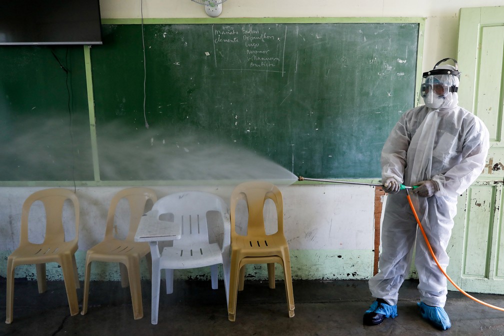 Funcionário desinfeta uma sala de aula dentro de uma escola, seguindo uma ordem do governo local em meio a novos casos de coronavírus no país, em San Juan, região metropolitana de Manila, nas Filipinas — Foto: Reuters/Eloisa Lopez