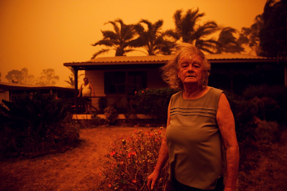 Nancy Allen e Brian Allen são vistos do lado de fora de sua casa enquanto ventos fortes empurram fumaça e as cinzas do incêndio Currowan em direção a Nowra, no estado de Nova Gales do Sul, na Austrália, em 4 de janeiro — Foto: Tracey Nearmy/Reuters